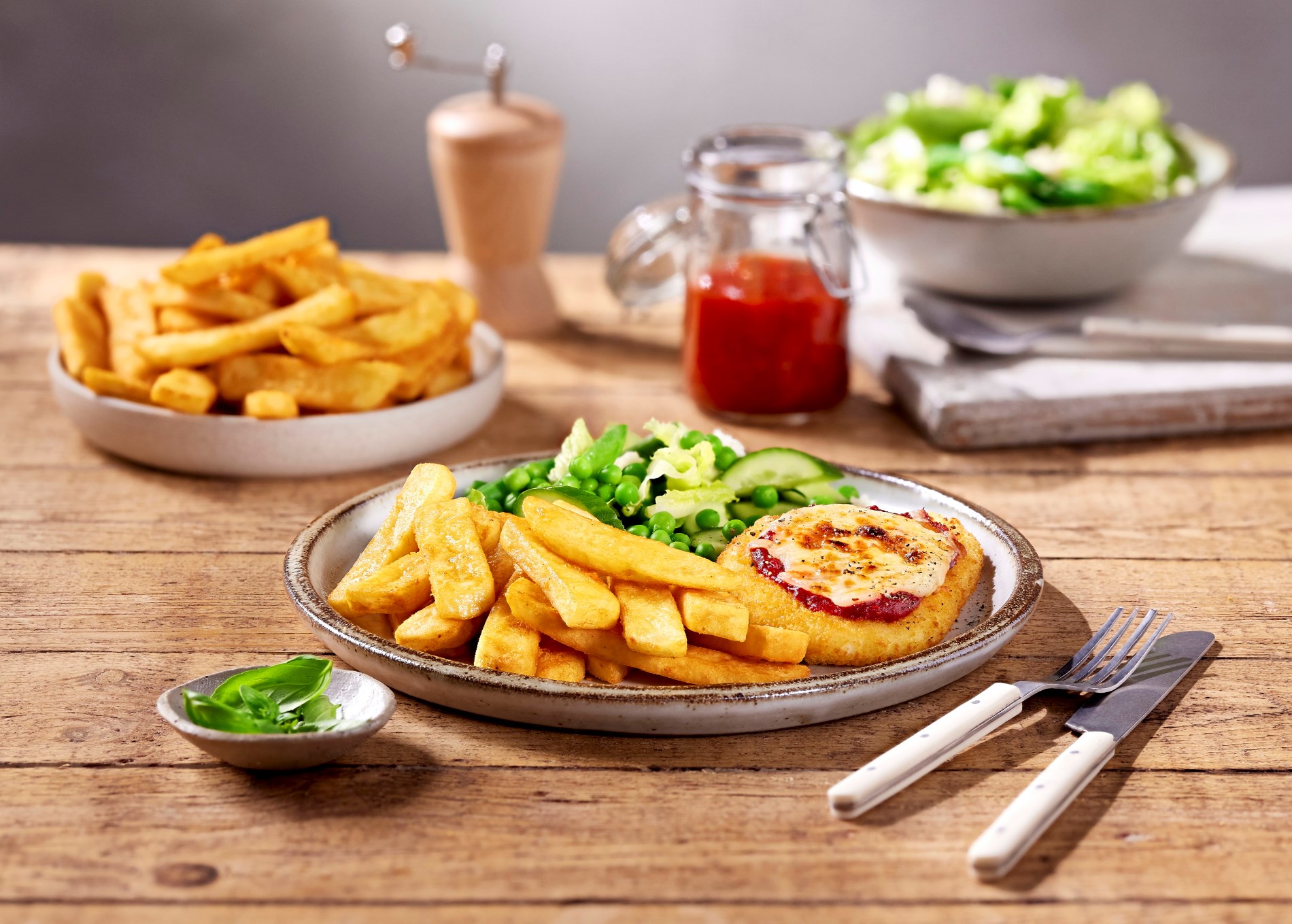 Chicken Parma with chips & pea salad